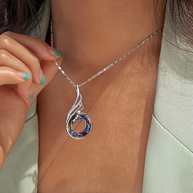 Ce collier est orné d'un pendentif circulaire en zircone synthétique de couleurs phénix, fabriqué en argent sterling S925. Il est idéal pour un usage quotidien et constitue un magnifique cadeau pour des occasions comme la Saint-Valentin, la fête des mères, les anniversaires.